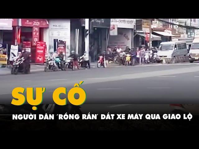 Đèn tín hiệu giao thông bị sự cố, người dân 'rồng rắn' dắt xe máy qua giao lộ ở Củ Chi