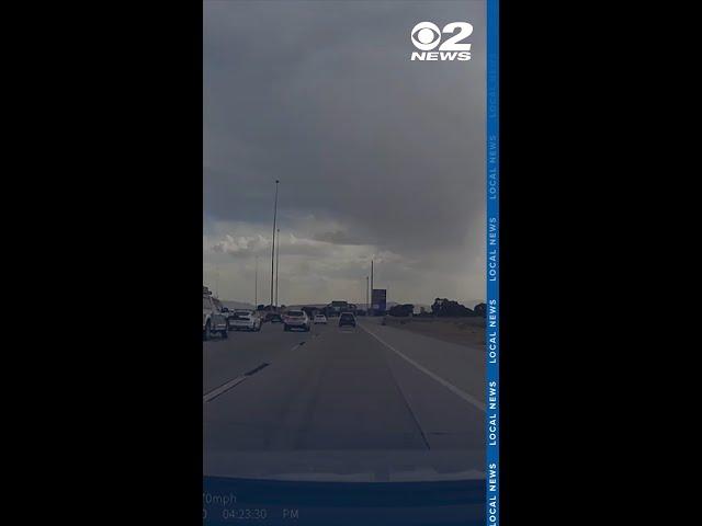 Dash cam video shows moment piece of metal went through the windshield of car on I-15