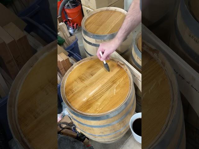 Using some black coffee to darken the surface of this whiskey barrel top.