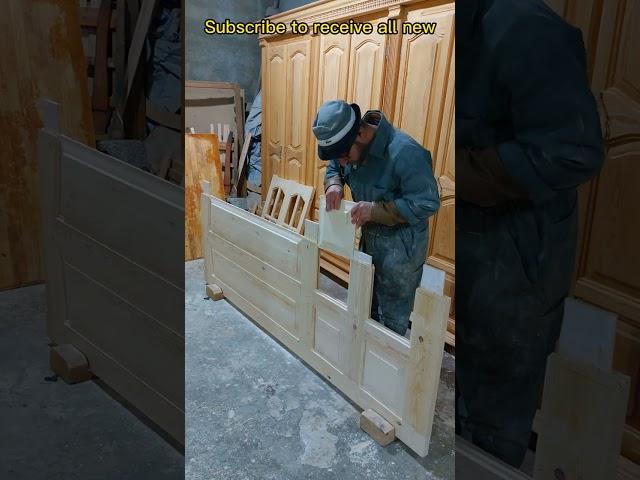 A skilled carpenter makes a red wood door quickly and efficiently
