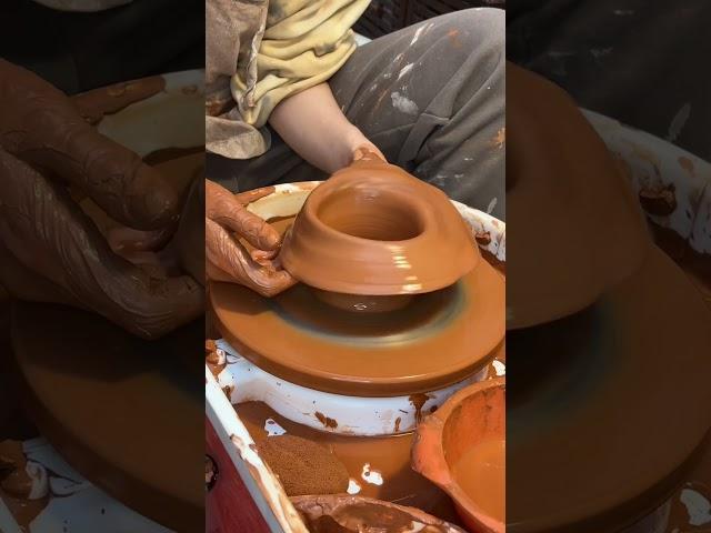 Person is trying to throw a vase on the pottery wheel and accidentally ruins it!