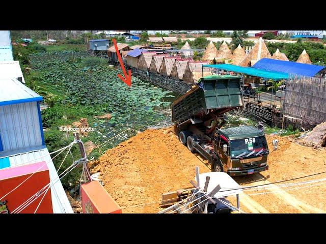 Dump truck wheel 10 unloading soil filling up with Bulldozer pushing soil into the water delete pond