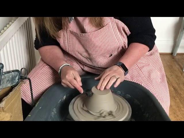 Trimming a pot on a pottery wheel