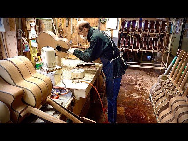 Process of making Acoustic guitar. Japanese guitar factory that plays classical music to the guitar