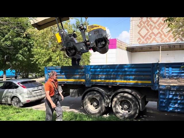 Манипулятор загружает  двухвальцовый  виброкаток GROST VR1000. vibrating roller GROSS VR1000.