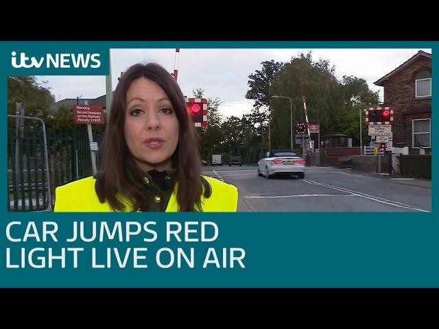 Car jumps red light at level crossing live on air | ITV News