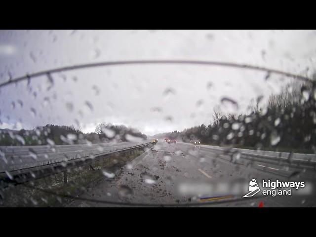 Car skids backwards on motorway during severe weather, narrowly avoiding traffic officer