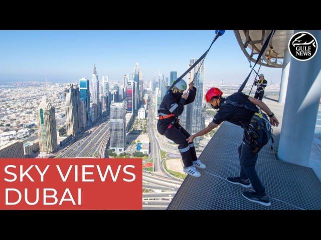 Walking along the edge of Sky Views Dubai | Glass slide | Sky Views Observatory