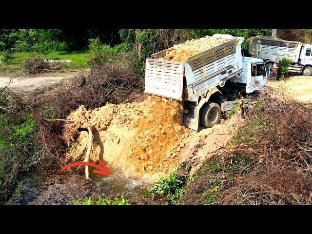 Wonderful First dump truck unloading stone into the build new road and bulldozer pushing fill up