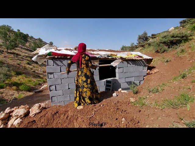 A single mother in the mountains:a baby in her arms and an unfinished hut