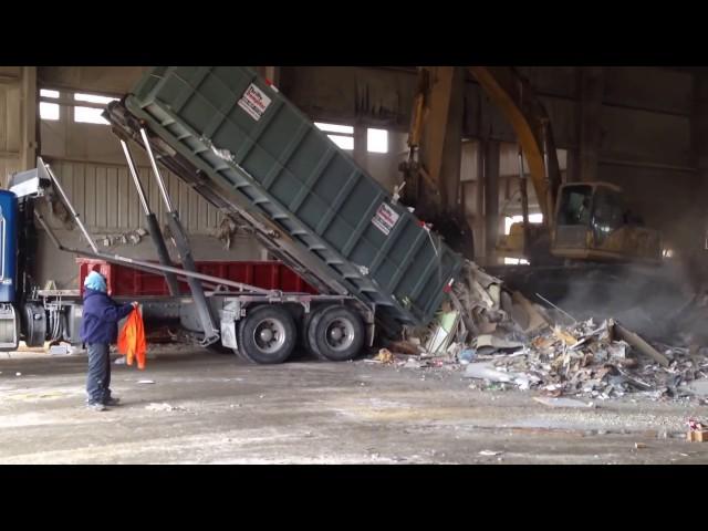 Frozen Dumpster getting scraped out with an excavator when it will not dump on its own