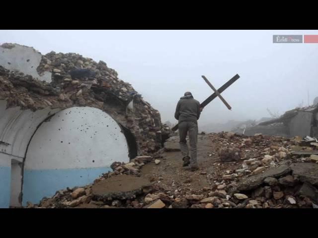 Ezidi fighters raising cross on a destroyed Assyrian church in Shingal