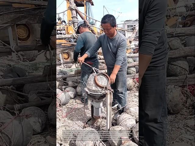 Cleaning buoys with a machine: men cleaning buoys with a machine