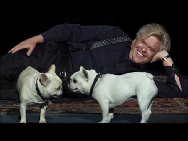 Ron White plays with his dogs on stage