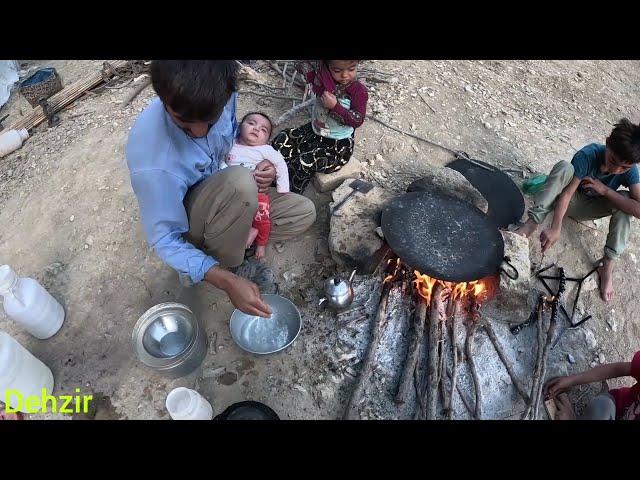 Preparing traditional bread for children's breakfast by nomadic father