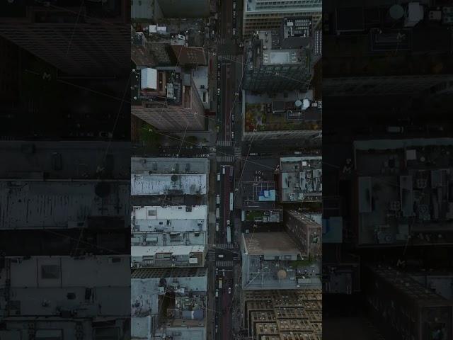 Vertical video reveals a Manhattan's bustling street with traffic and towering skyscrapers' rooftops