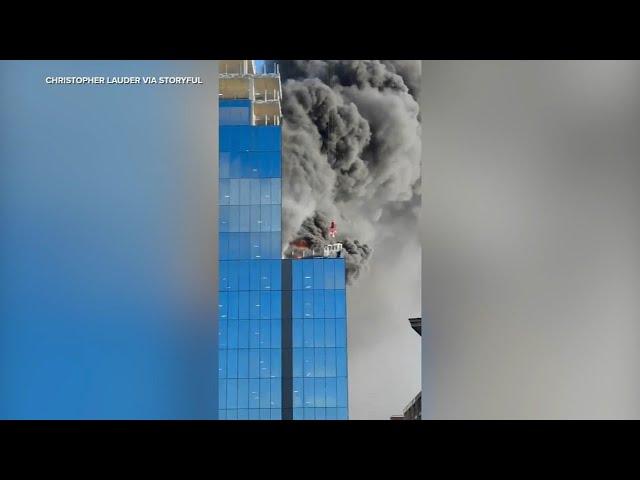 Crane operator rescues man from burning high-rise in England, video shows