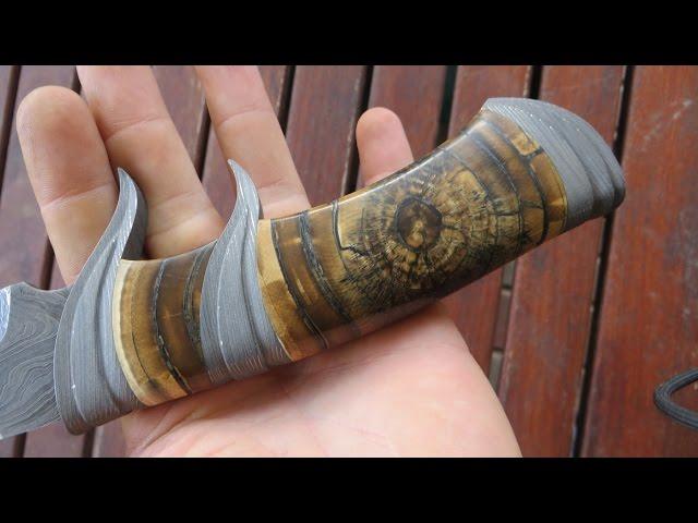 A knife with a handle made of mammoth tusk end Damascus