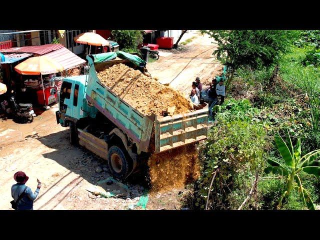 Perfectly action people pouring soil to build houses using dozer and truck7KIP spreading soil