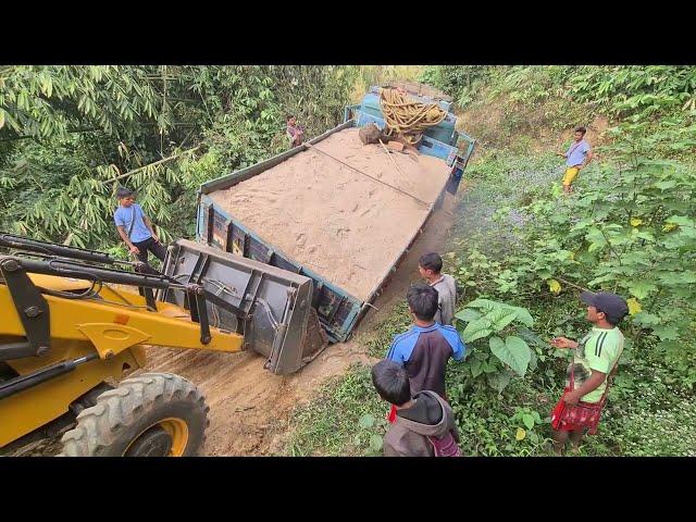 jcb backhoe loader helping a truck stuck in a hole