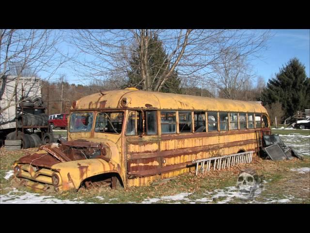 Abandoned vehicles in America: old cars, rusty tractors. Abandoned bus.