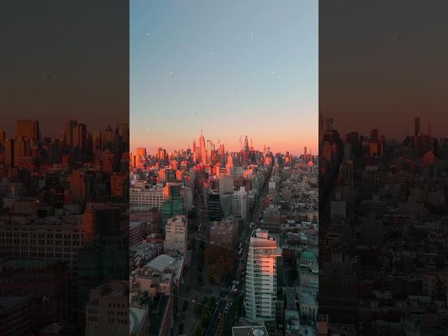 Camera gliding over Midtown Manhattan's iconic skyline during golden hour, highlighting NYC