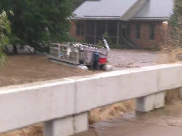 Drifting boat ripped below bridge as Roan Mountain floods