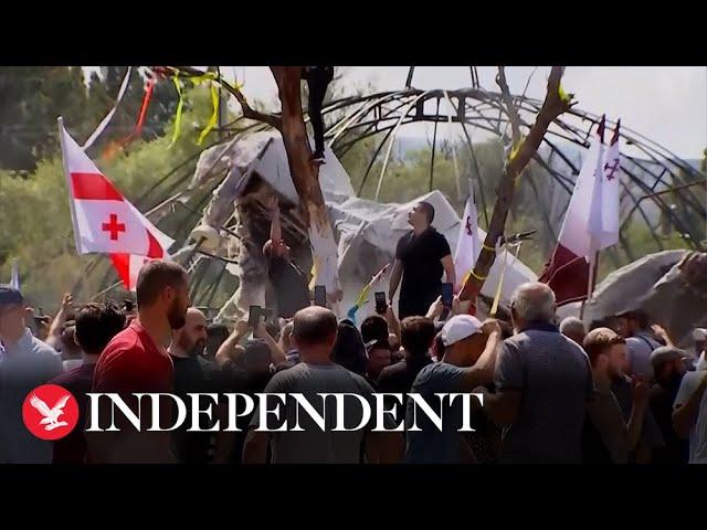 Anti-LGBT protesters burn flags and tear down float as they storm Georgia’s Pride parade