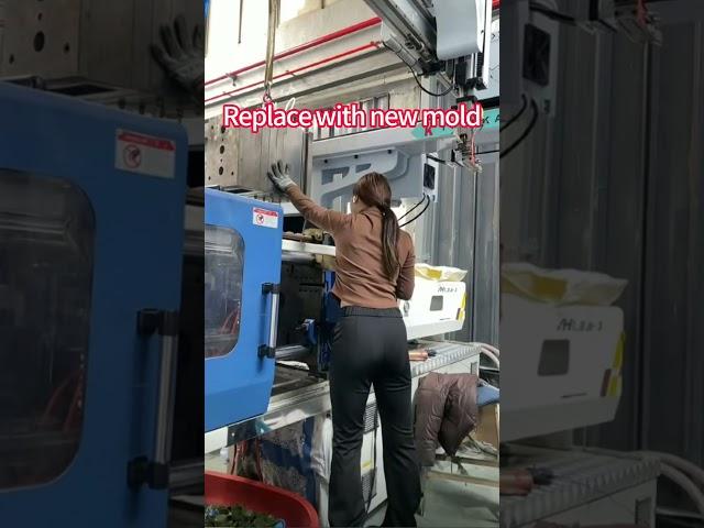 Girl changing molds in injection molding factory