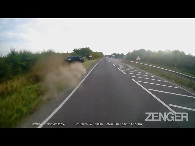 This video shows a car crashing into a ditch as it overtakes a lorry