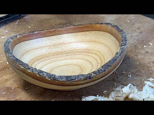 Richard Raffan turns a firewood scrap of bone-dry claret ash into a bark-rimmed bowl.