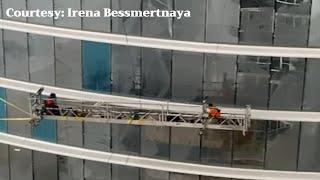 High winds cause workers to swing on scaffolding