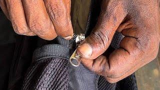 Cobbler repairing a bag zip