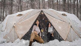 吹雪の中で暖かく居心地の良いテントでキャンプ