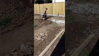 trench raised patio man on shovel enjoying himself not lol