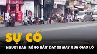 Đèn tín hiệu giao thông bị sự cố, người dân 'rồng rắn' dắt xe máy qua giao lộ ở Củ Chi