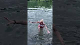 Woman Slips Into Water While Greeting Approaching Dolphins