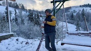 Rural winter life of a young man in the mountains. Everything is covered with snow