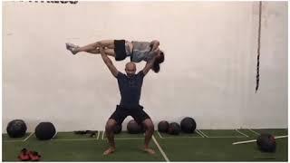 Man Does Sit Ups While Lifting Woman Overhead