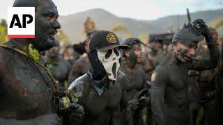 Mud-covered Carnival revelers are a strange sight in sleepy Brazilian town