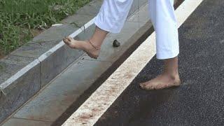 （裸足，barefoot）The girl practicing Taekwondo walks barefoot in the mud to relax her soles