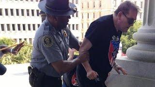 Black police officer helps demonstrator at KKK rally