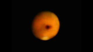 What is this dark object passing in front of Mars?