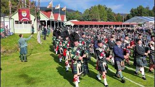 Massed Pipes & Drums Games field march with Atholl Highlanders at 2024 Braemar Gathering in Scotland