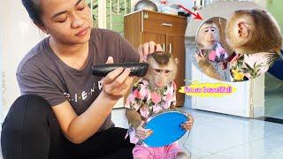 Monkey Lyly curiously checked in the mirror to see if her mother cut her hair nicely or not.