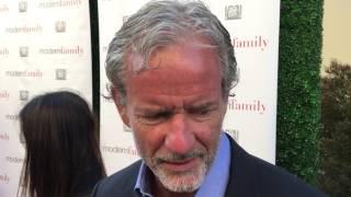 Co-creator Christopher Lloyd chats on the "Modern Family" red carpet for an Emmy voter FYC screening