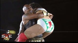 Black muscular woman bearhugs her white-clad opponent