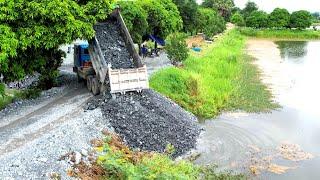 First Dump trucks Wheel 10 unloading Stone into the water with Bulldozer pushing Stone delete pond.