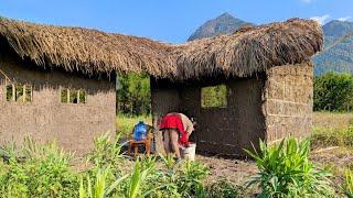 Single mother continues to build house with grass and soil in the forest