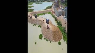 Amazing bulldozer and dump trucks filling land into the water to make road